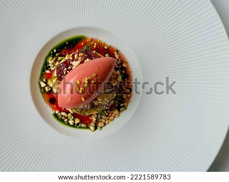 Fine dining: A quenelle of strawberry sorbet on dill oil and topped with crumbs Royalty-Free Stock Photo #2221589783