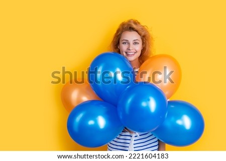 cheerful girl hold party balloons in studio. girl with balloon for party isolated on yellow