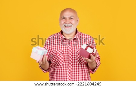 positive old man with present box for anniversary