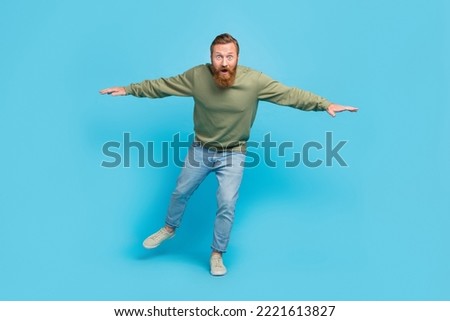 Full size photo of handsome young guy nervous try keep balance walk invisible tightrope wear khaki look isolated on cyan color background Royalty-Free Stock Photo #2221613827