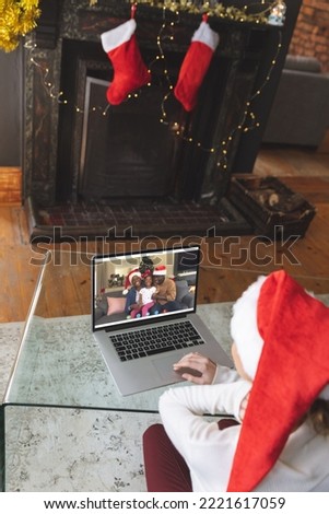 Caucasian woman having christmas video call with african american family. Communication technology and christmas, digital composite image.
