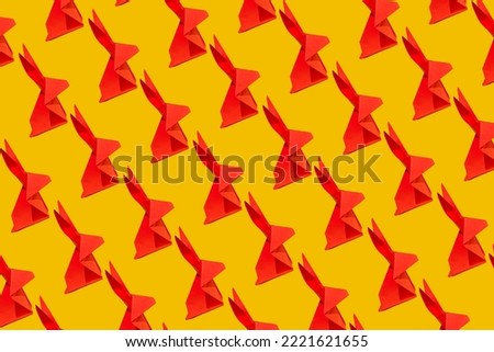 Creative seamless printable pattern design made of red paper rabbit on a vibrant yellow background. Lunar, Chinese New Year greeting cad for 2023. Year of the Rabbit.