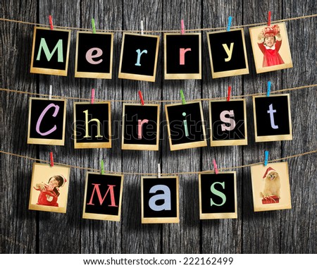 Merry christmas words hanging on clothesline on wood background.