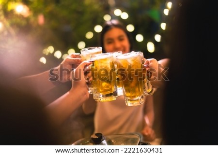Evening group of friends drinking beer and clinking glasses. Royalty-Free Stock Photo #2221630431
