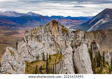 Two tiny hikers in grandeur of Sapper Hill wilderness landscape near Dempster Highway in Ogilvie Mountains of Yukon Territory, YT, Canada Royalty-Free Stock Photo #2221635895
