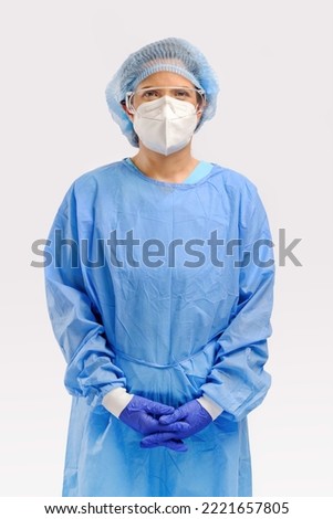 studio portrait of 40s hispanic female surgery doctor or researcher with full protective cloth of PPE gown face mask cap and surgery glove isolated on white background Royalty-Free Stock Photo #2221657805