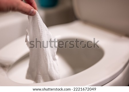 Disposable wipes being flushed down a toilet where they can cause clogging and problems with wastewater treatment. Royalty-Free Stock Photo #2221672049