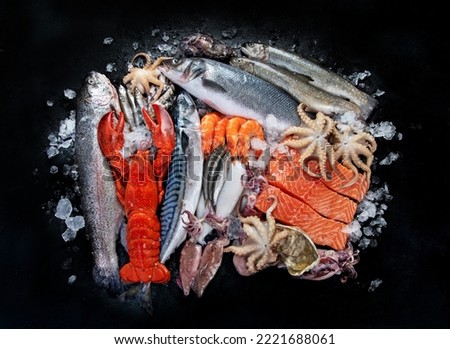 Fresh fish and seafood assortment on black background, fish market. Healthy diet eating concept. Top view., copy space. Royalty-Free Stock Photo #2221688061