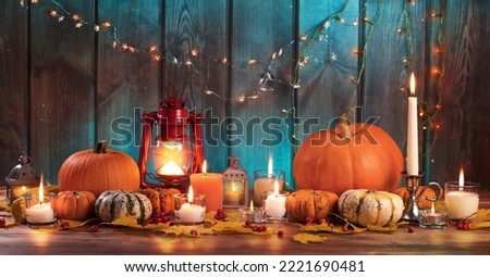 Pumpkins and candles on a wooden table. Thanksgiving holiday and autumn harvest festival concept.