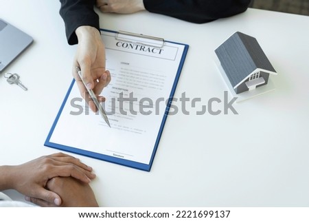 An Asian female sales representative is discussing the details before the customer agrees to sign the contract. By explaining the details and terms and conditions of the rental real estate concept.