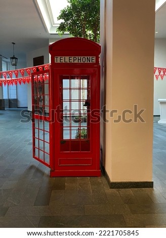 Photograph of hundreds of Turkish flags and a vintage brightly lit red telephone booth, photographed in the evening 