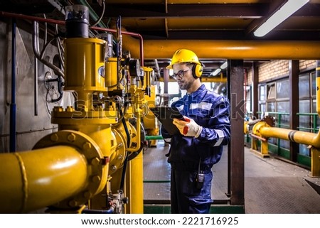 Engineer checking heat pumps in heating plant. Royalty-Free Stock Photo #2221716925