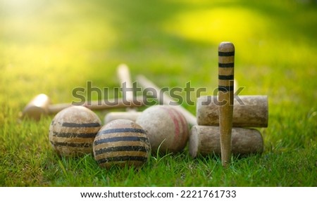 An antique set for playing croquet on the green grass. Wooden clubs with striped balls. Victorian outdoor games. Royalty-Free Stock Photo #2221761733