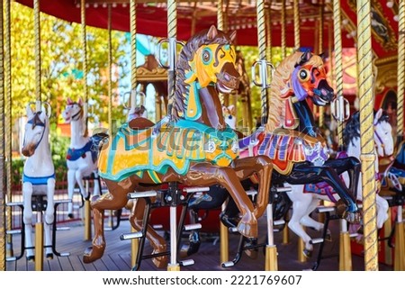 Carousel with horses in the city park. Entertainment for children.