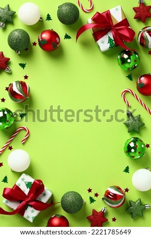 Christmas frame. Flat lay festive Christmas decorations, gift boxes, candy canes, confetti on light green background. Christmas vertical banner design, Happy New Year party invitation card design.