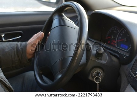 The picture shows the interior of the car, you can see the speedometer and the driver's hands on the steering wheel.