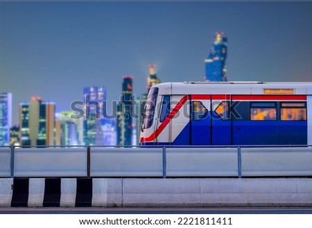 Bangkok SkyTrain stops on train tracks with blurred city background on night scene and copy space, Sky Train is a mass transit system in Bangkok to assist facilitate and  fast journey Royalty-Free Stock Photo #2221811411