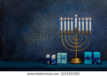 Jewish Hanukkah Menorah 9 Branch Candlestick, gift box. Holiday Candle Holder. Nine-arm candlestick. Traditional Hebrew Festival of Lights candelabra. Background for design with copy space. Royalty-Free Stock Photo #2221823385