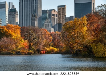 Autumn in Central Park at The Lake with brilliant fall foliage and Midtown skyscrapers. Manhattan, New York City