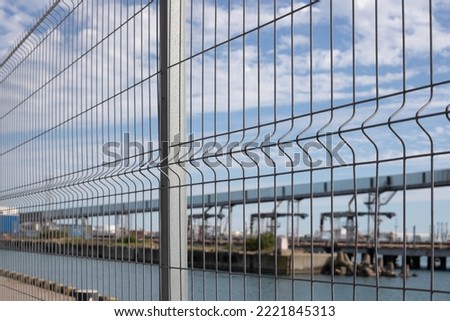 A metal fence closes the seaport. Royalty-Free Stock Photo #2221845313