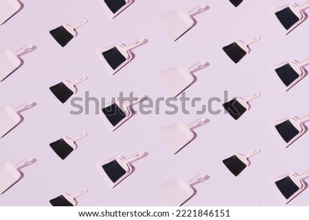 Pink plastic broom with a spatula. Pastel background. Pattern.
