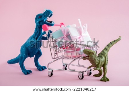 Two cute dinosaurs with shopping trolley full of present boxes on pink background. Sale concept.