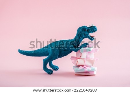 Cute blue dinosaur with stack of present boxes on a pastel pink background.