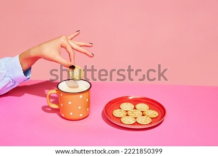 Goodies. Food pop art photography. Young girl tasting milk with crackers isolated over pink background. Concept of art, creativity. retro 80s, 70s style. Complementary colors. Copy space for ad