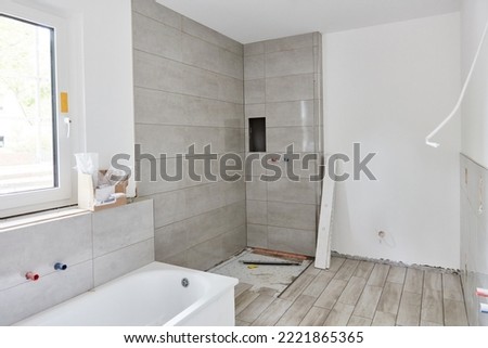 New bathroom with shower and bath with new tiles after repainting at home construction Royalty-Free Stock Photo #2221865365