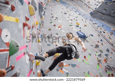 Woman climbing indoor rock wall