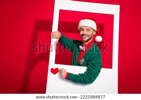 Photo of charming positive man wear x-mas bowtie green cardigan shooting getting heart likes isolated red color background