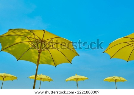 yellow umbrella against blue sky                               