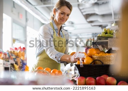 Worker arranging produce in market