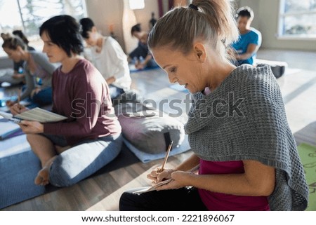 Women with journals at restorative yoga retreat Royalty-Free Stock Photo #2221896067
