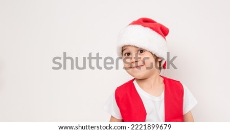 Portrait of smiling beautiful child in red Santa Claus hat isolated on white background. 5 year happy little European boy. Banner. Copy space. Christmas time mockup design. New Year holiday. Fun kid.