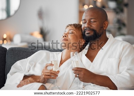 Mature couple, bonding and champagne on spa date, romantic retreat or resort holiday for marriage anniversary celebration. Black woman, man and alcohol glass on relax salon or hotel living room sofa Royalty-Free Stock Photo #2221902577