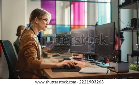 Caucasian Woman Coding on Desktop PC and Laptop Setup With Multiple Displays in Spacious Office. Female Junior Software Engineer Working on New Sprint of Mobile Application Development For Start-up. Royalty-Free Stock Photo #2221903263