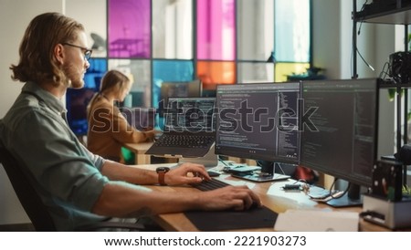 Caucasian Man Coding on Personal Computer and Laptop Set Up In Stylish Office. Professional Programmer Developing Innovative AI Software in Technological Start-Up, Using Multiple Displays. Royalty-Free Stock Photo #2221903273