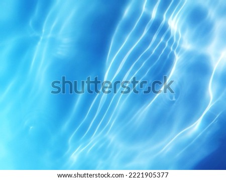 Closeup​ blur​ abstract​ of​ surface​ blue​ water​ in​ the​ deep​ sea​ for​ background. Reflection​ of​ sunlight​ with​ surface​ blue​ water​ for​ graphic​ design.