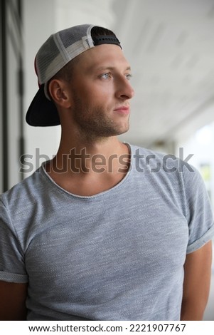 Portrait of handsome young man in stylish cap outdoors