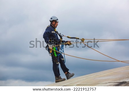 Male workers clear rope access wearing safety first harness rope safety line working at a high.