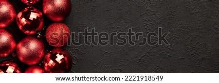 Christmas banner with red bauble balls decorations on black background with copy space. Wide panoramic header