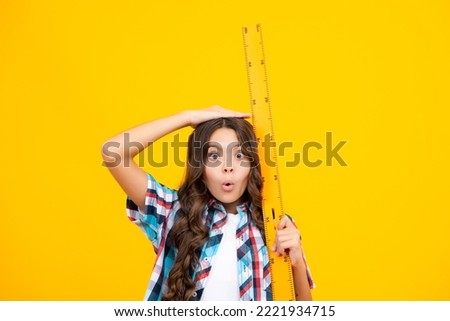 Funny face. Teenager child school girl holding measure for geometry lesson. Measuring height. Measuring equipment. Kid student study math.