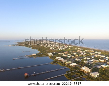 Stilt houses with long docks in the low-lying town of Grand Isle, Louisiana Royalty-Free Stock Photo #2221943517