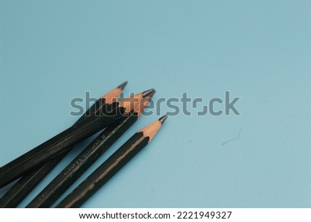 a close up of a bunch of pencils isolated on a blue background. creative photo concept.