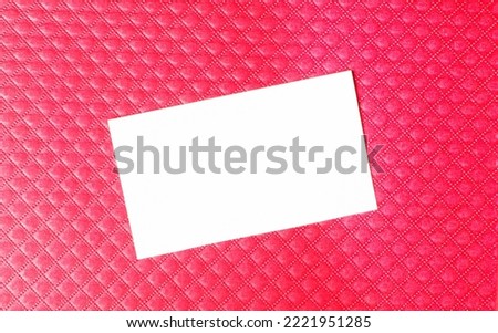White blank business card with space to insert text on a red background. Copy space
