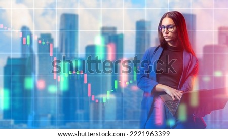 Woman investor. Businessman with laptop. Girl is engaged in trading. Woman with laptop in business clothes. Falling chart behind businesswoman. Modern skyscrapers behind investors. Investment trader
