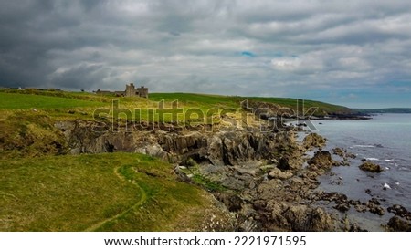 Overcast cloudy sky over the rocky coast of Ireland. Beautiful nature of northern Europe. Green fields on the coast. Aerial photo.