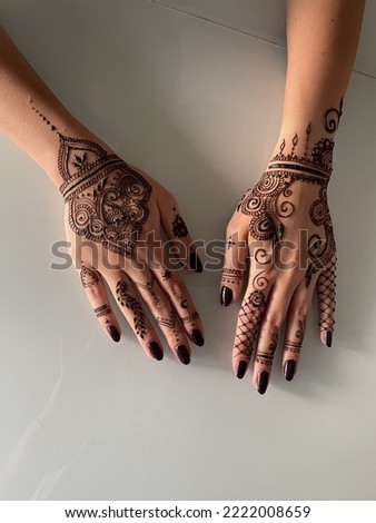 Traditional henna art tattoo on the hands. Bridal mehndi. Indian wedding tradition. White background. Royalty-Free Stock Photo #2222008659