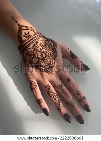 Traditional henna art tattoo on the hands. Bridal mehndi. Indian wedding tradition. White background. Royalty-Free Stock Photo #2222008661